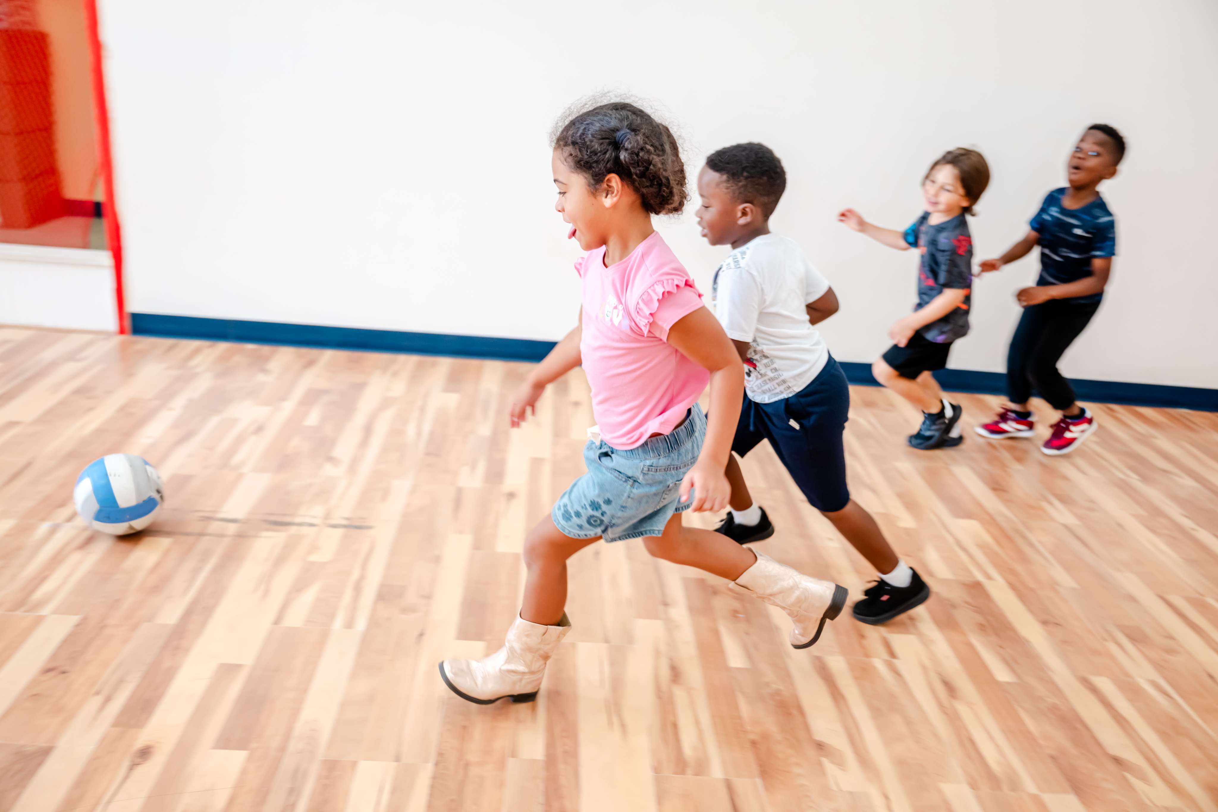 Children running and playing actively in the indoor gym at Little Newtons Academy